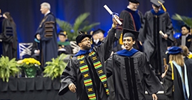 graduating student holding up diploma