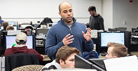 Instructor in a computer lab working with students looking at their screens